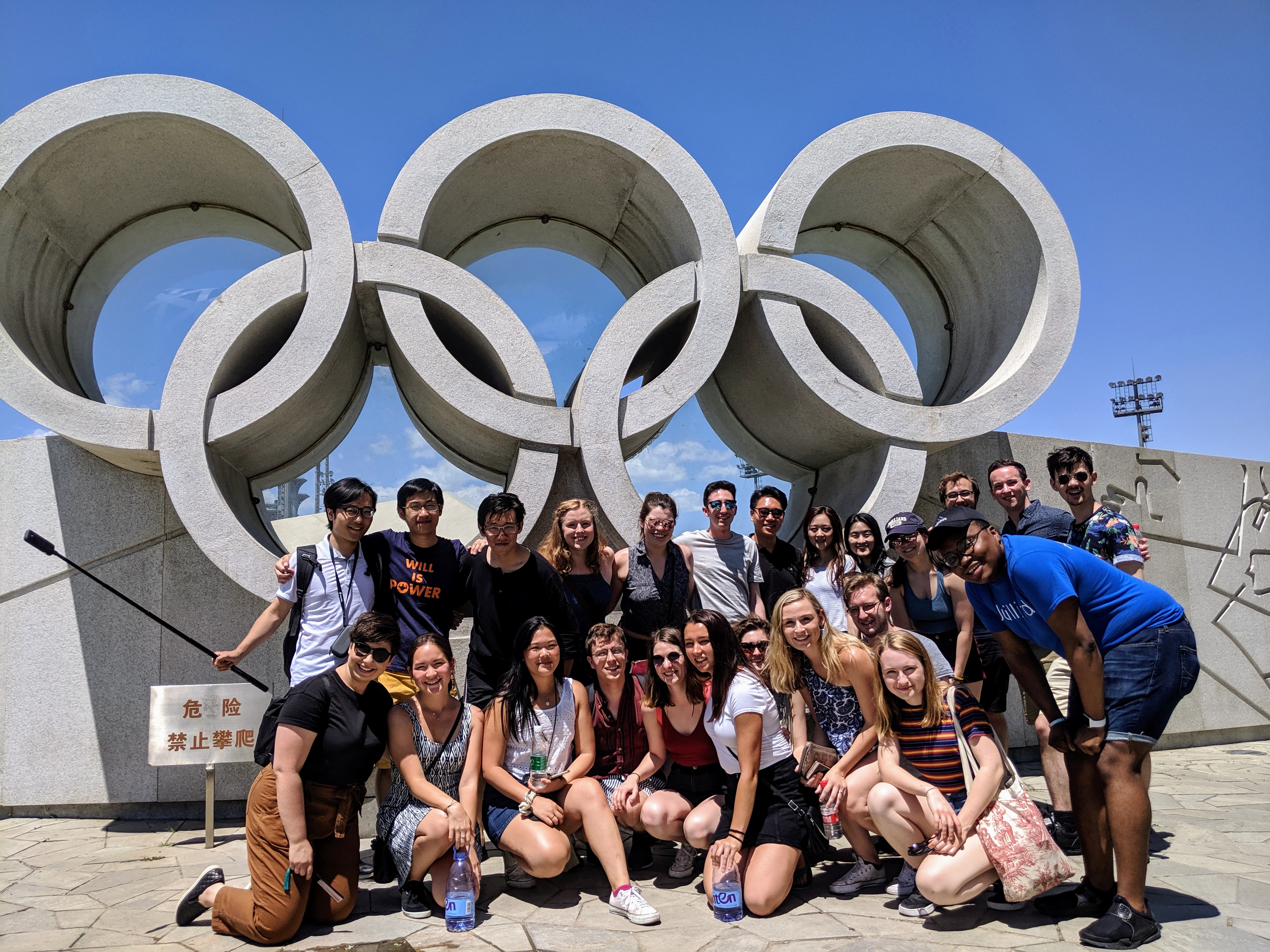 A group of students pose by Olympic rings