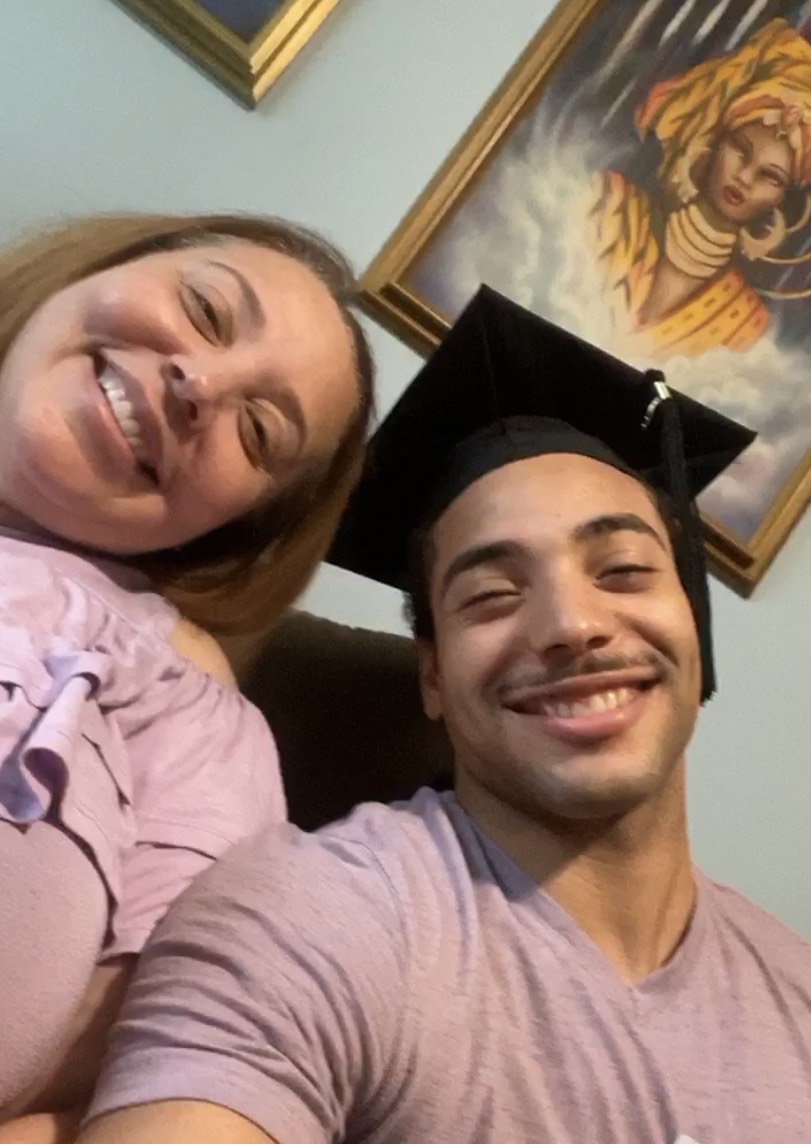 Jalen and a family member celebrating commencement at home