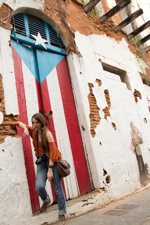 Gabriela posing by a doorway with the Puerto Rican flag painted on it