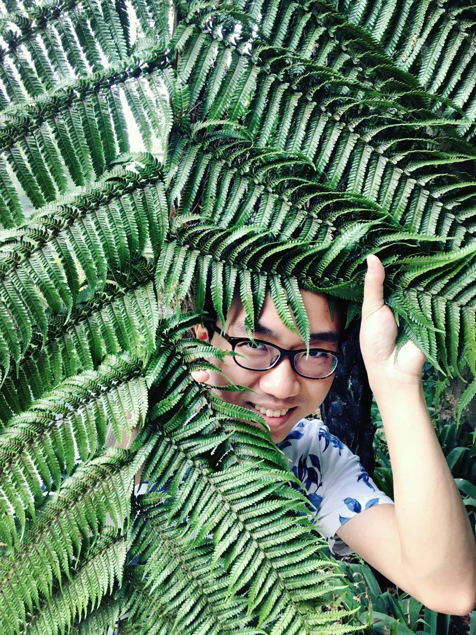 A student posing with a fern 