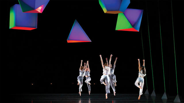 Dancers leaping on stage.