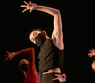 Dancer Nicole Leung is in the foreground and there are two dancers behind her in this performance photo