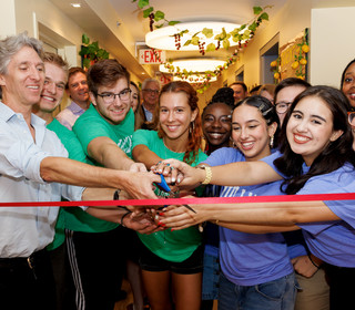 Juilliard's president and a group of students cutting a ceremonial ribbon in the residence hall