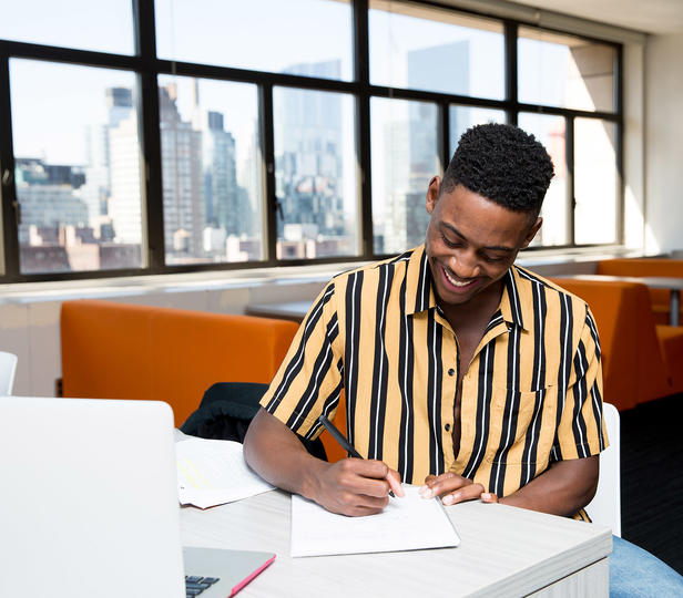 student sitting at desk in residence hall lounge