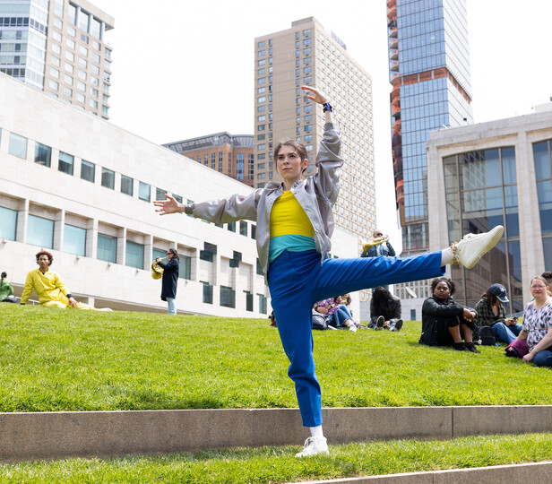 casually dressed student striking a pose outside of juilliard on the grass