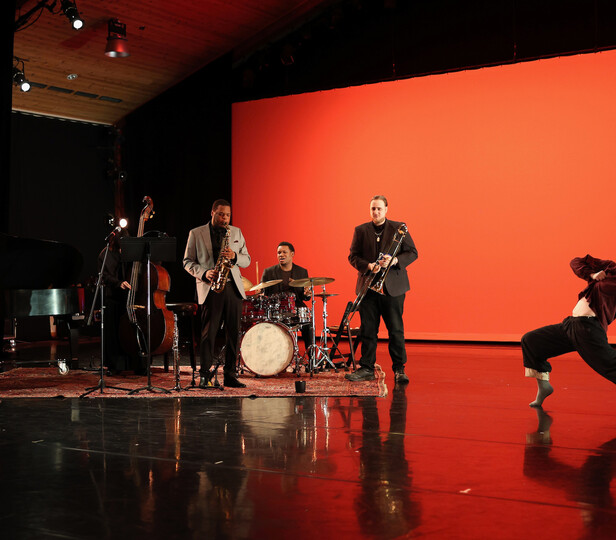 performers on an orange lit stage