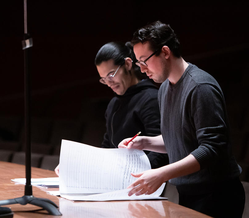 Student composers standing at rehearsal with music