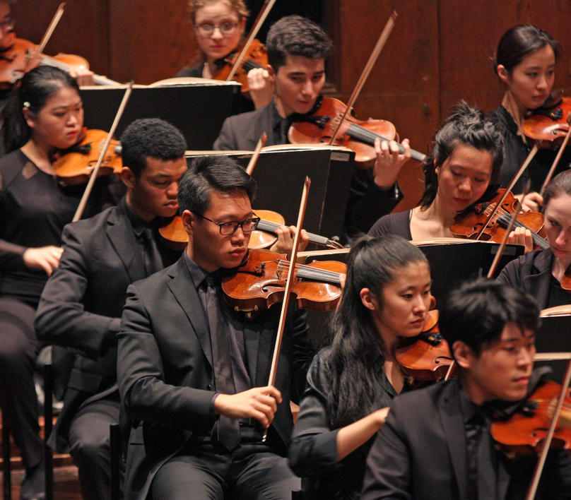 The Violin section of the orchestra performing