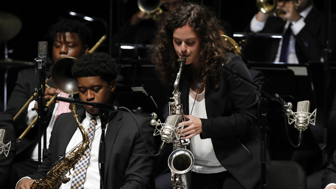 A female jazz student plays the saxophone during a concert as part of the jazz ensemble