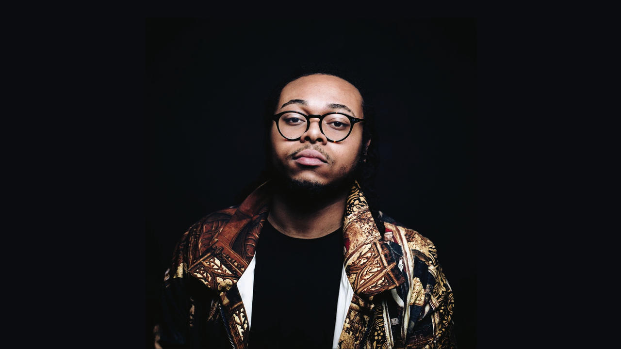 Immanuel Wilkins dressed in a fashion jacket against a black background