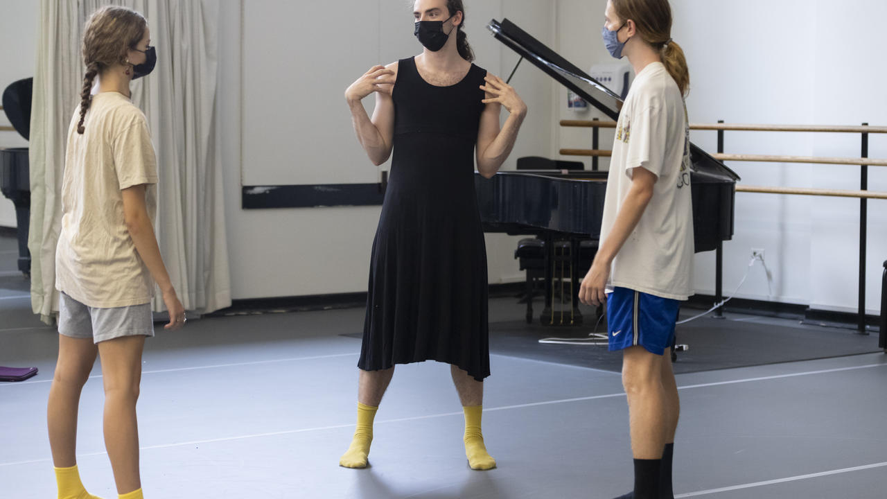 Three dancers in a studio having a conversation or planning their project