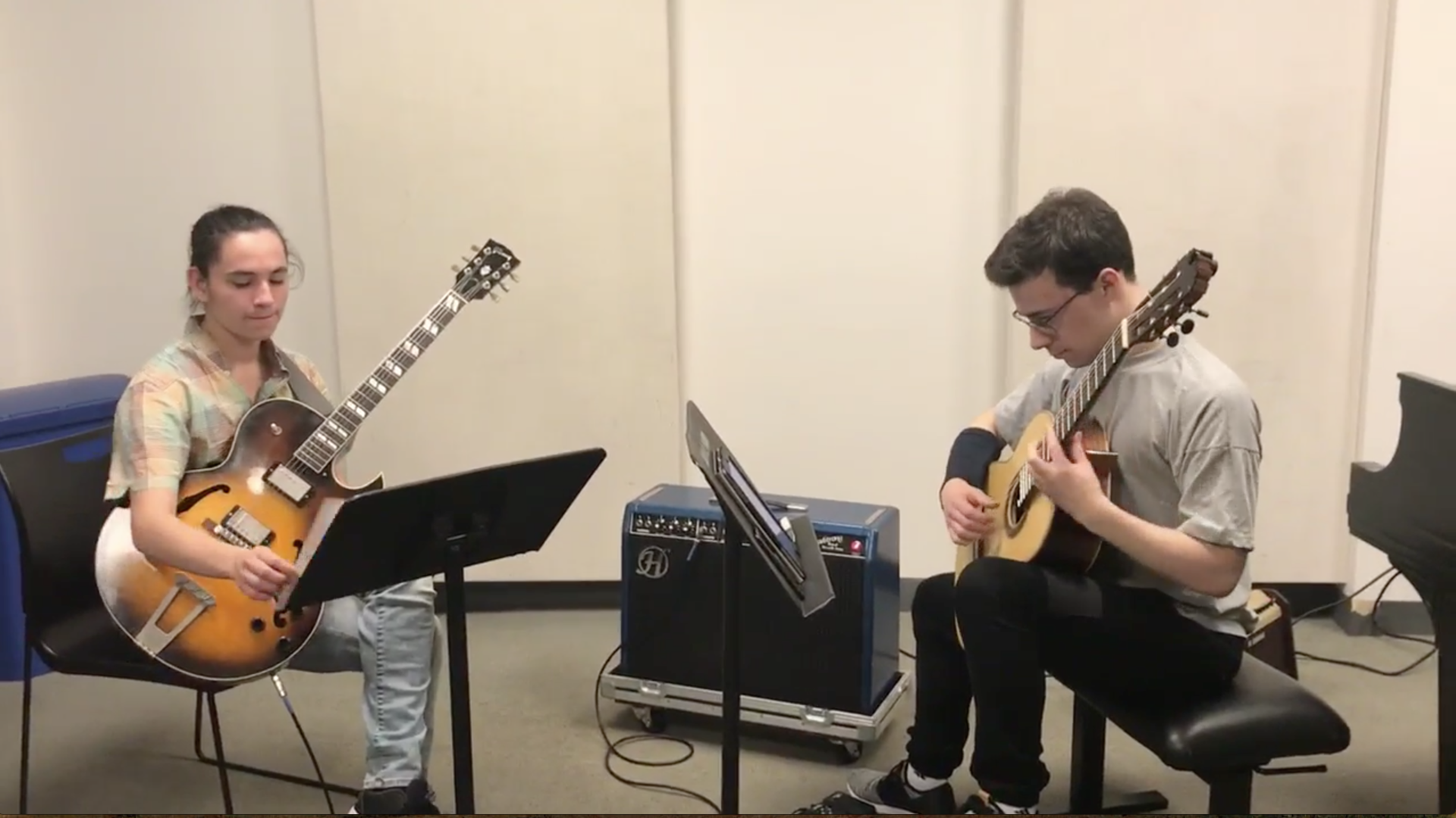 Two students practicing guitars