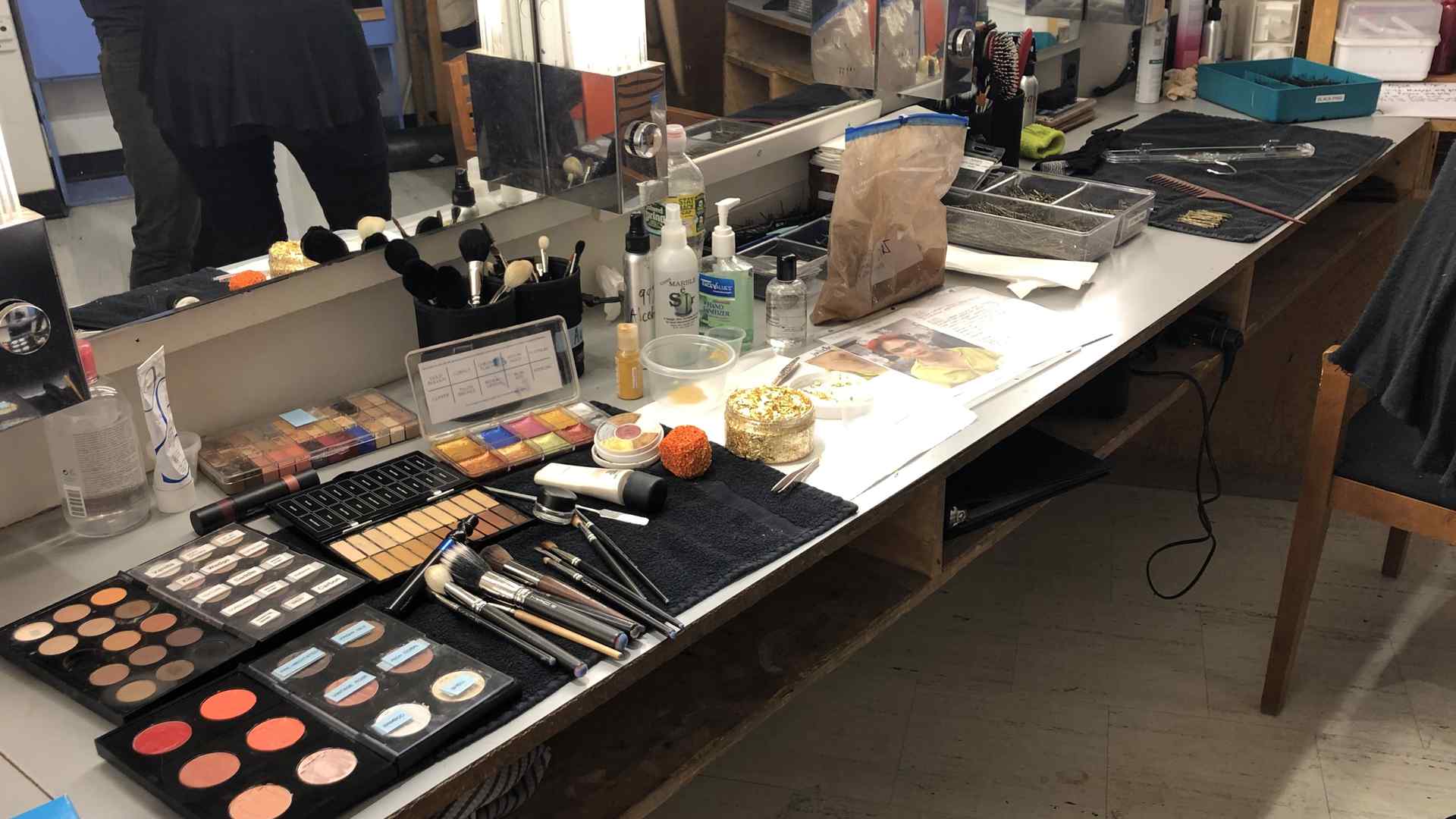 A dressing room counter covered with makeup