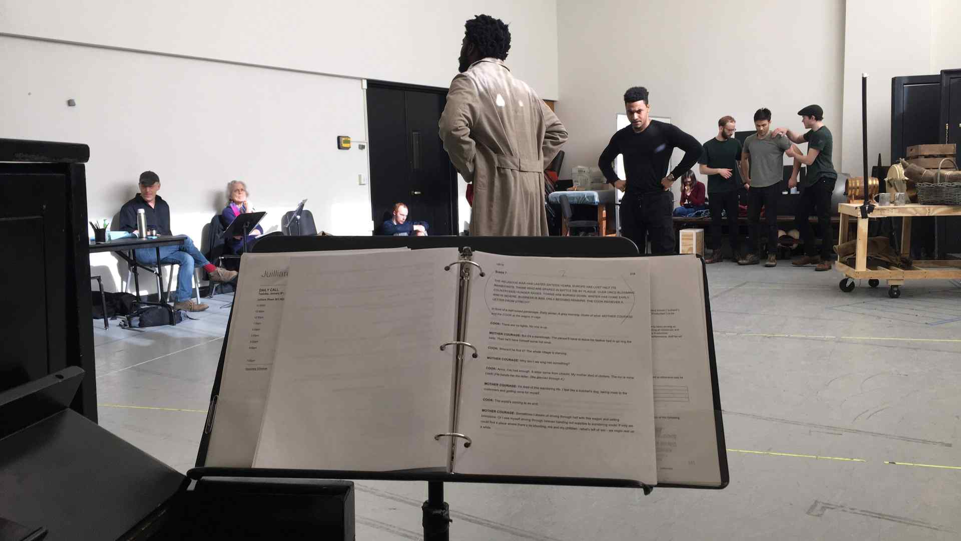 A music stand and actors rehearsing 