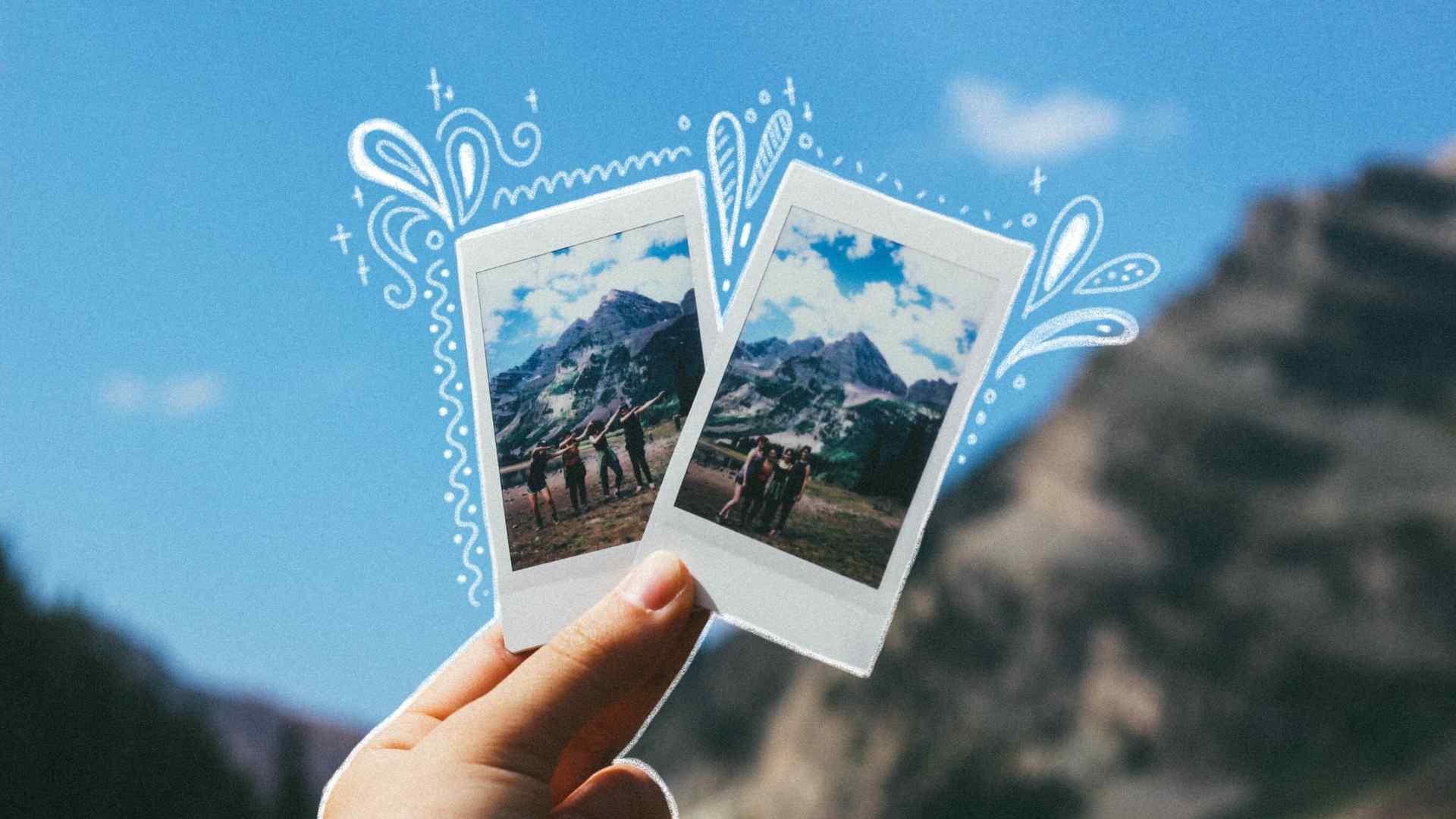 Mei holds two Polaroids of mountains in front of a mountain scene