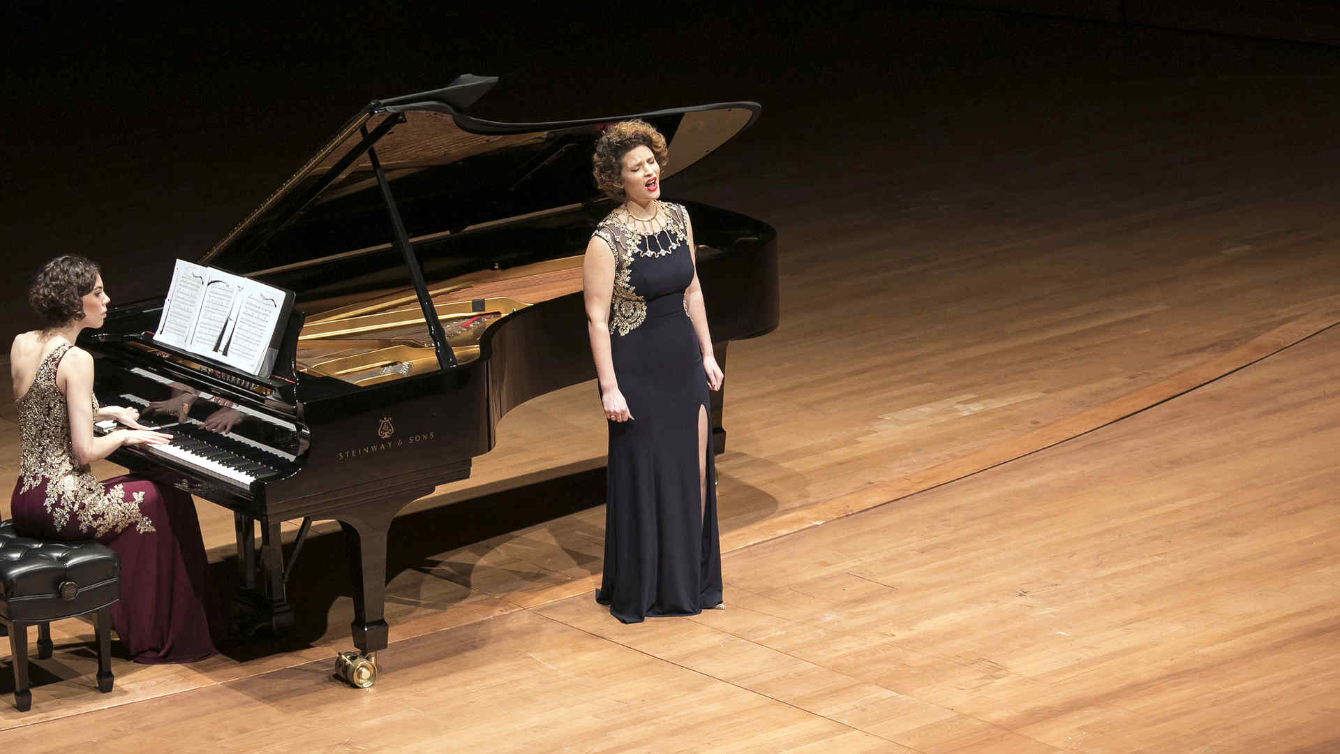 Collaborative pianist Bronwyn Schuman is at the piano accompanying a singer during a recital on stage