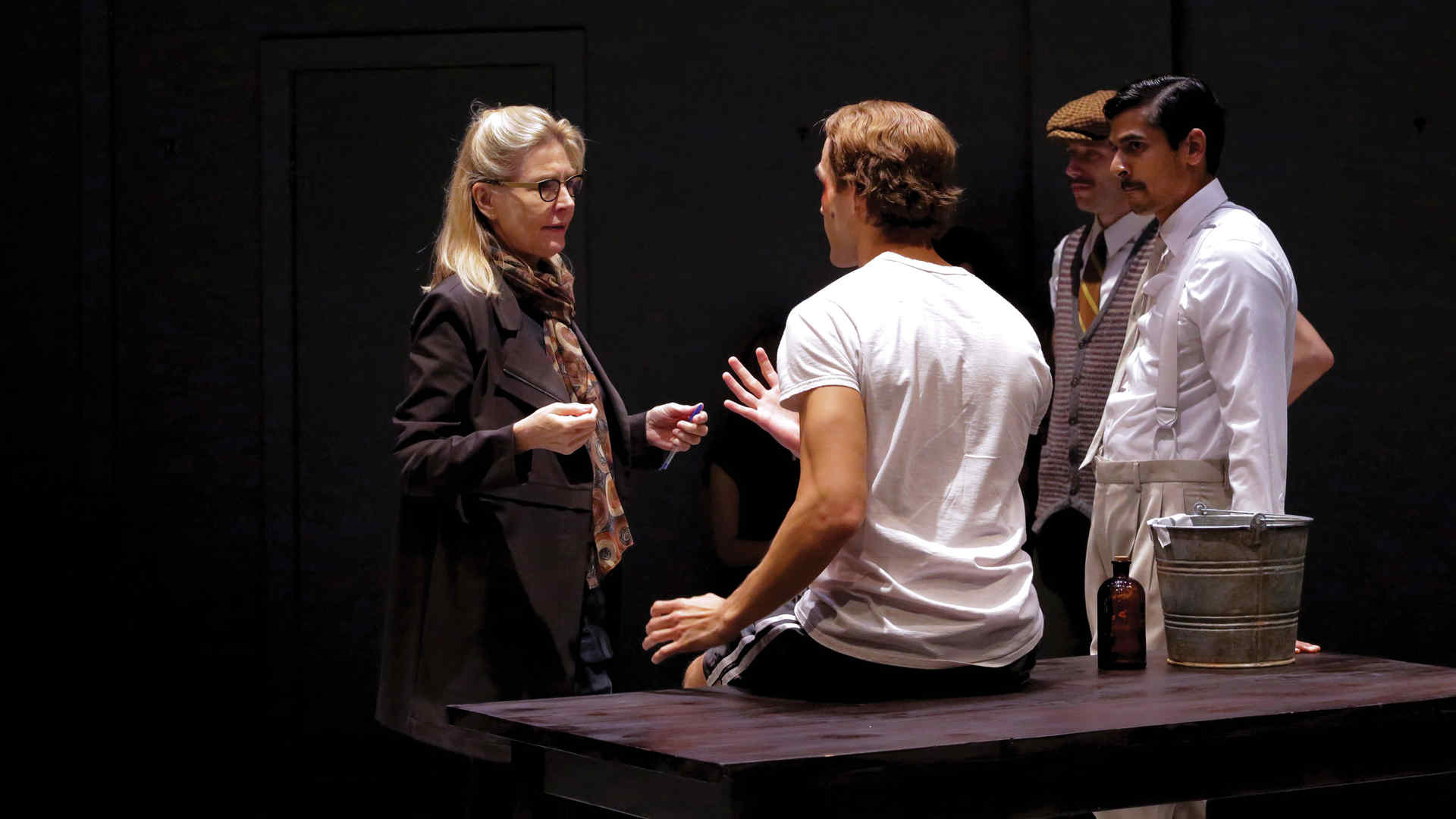 Director and alumna Janet Zarish in rehearsal with three actors 