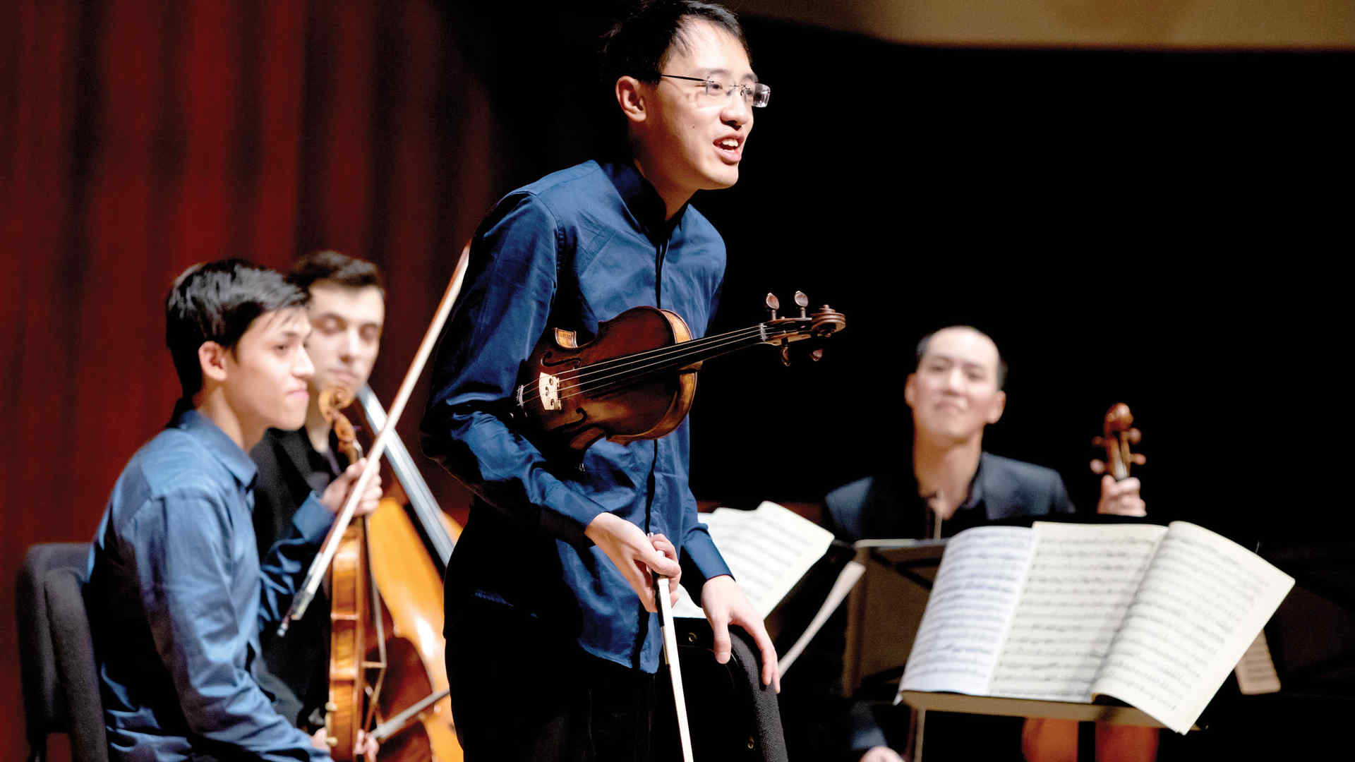 Violinist Max Tan with three colleagues from his chamber music group on stage during ChamberFest