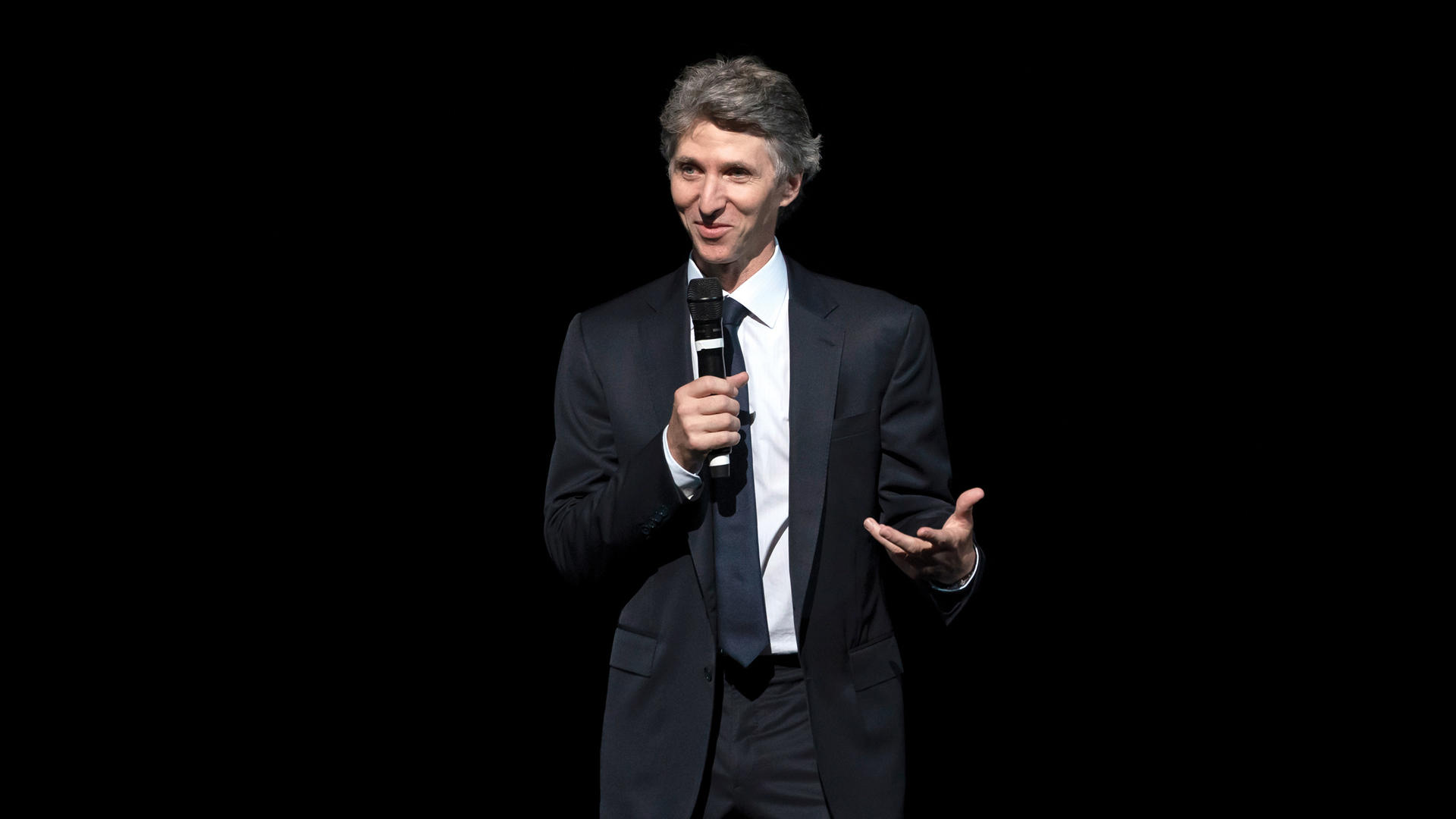 Juilliard President Damian Woetzel is speaking from the stage, microphone in hand, at Convocation