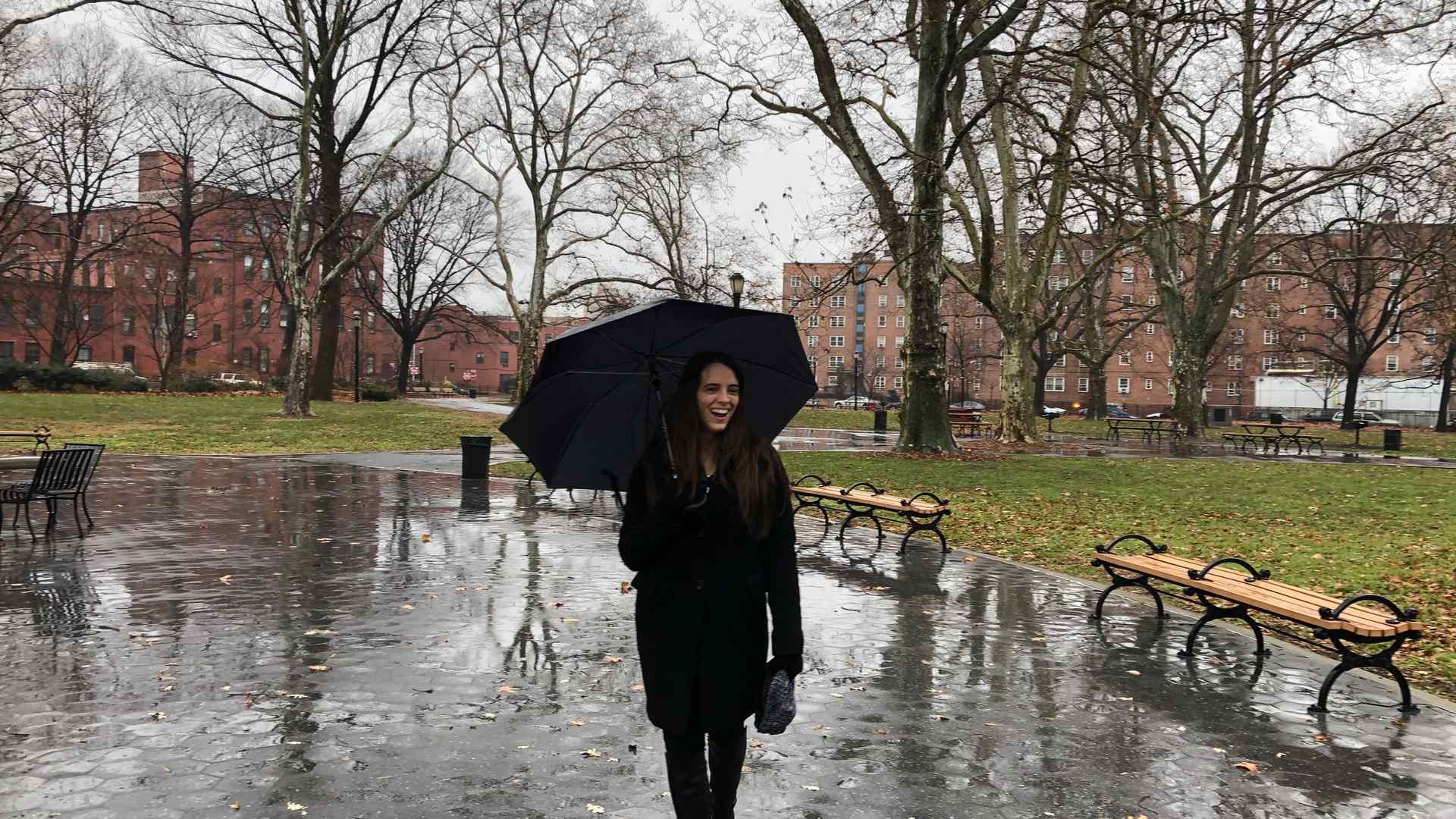 Gabriela stands on a rainy street