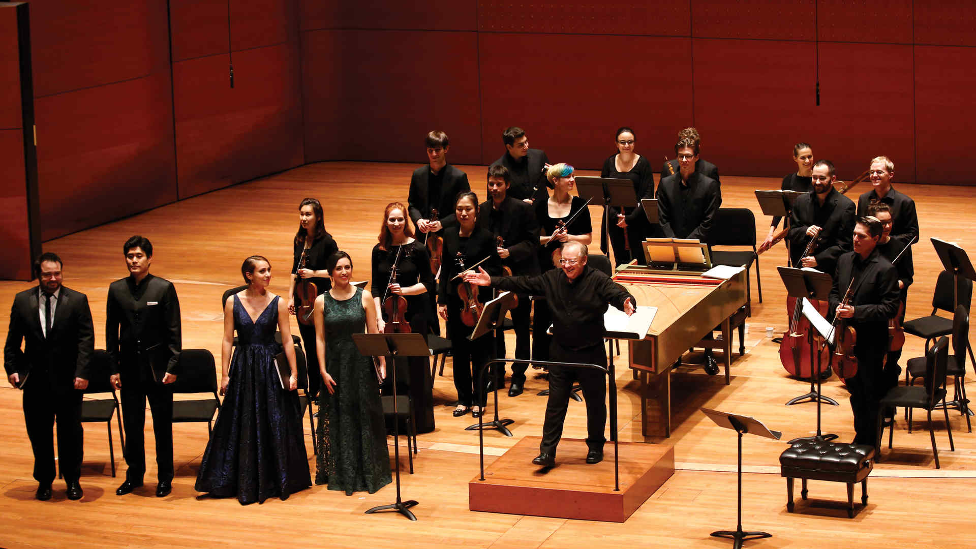 Nicholas McGegan on the podium with Juilliard415 behind him in Alice Tully Hall last spring. The musicians are standing as they receive applause