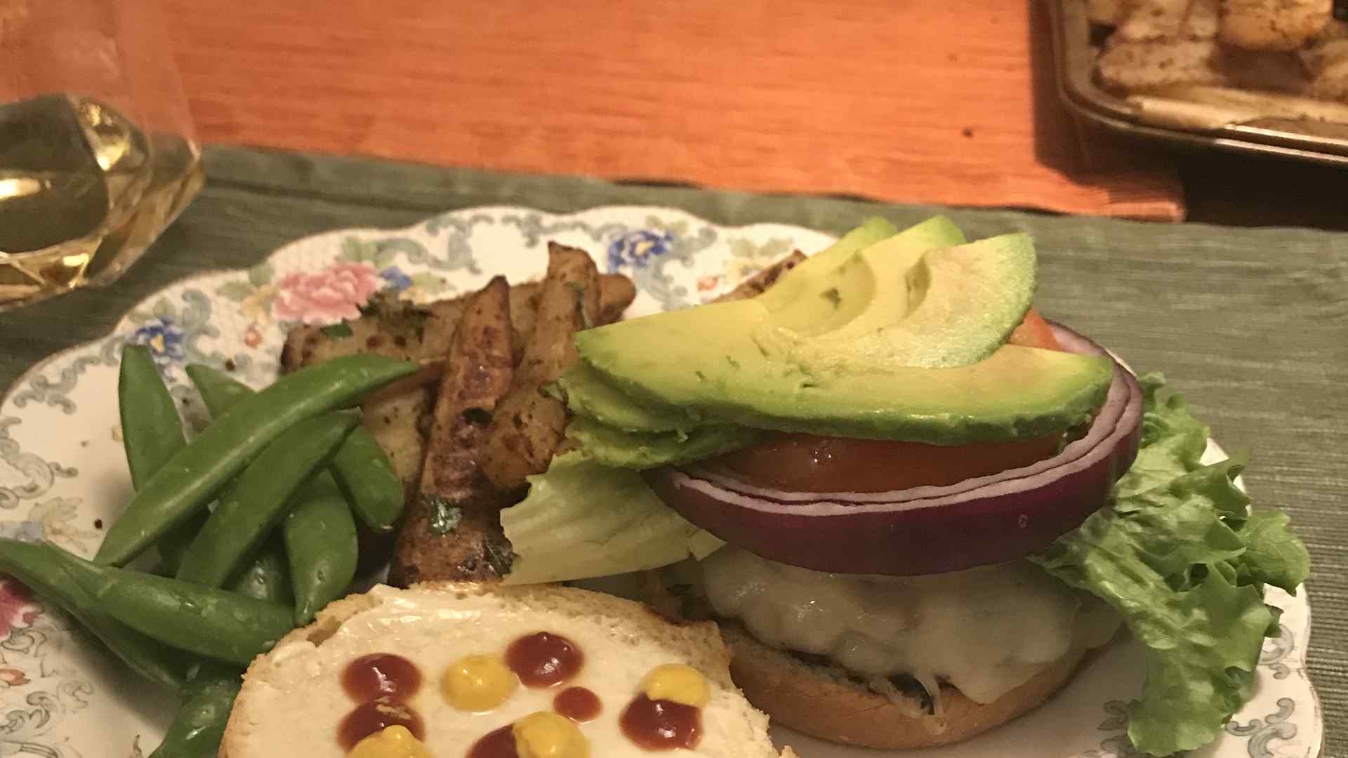 A plate with a burger and green beans