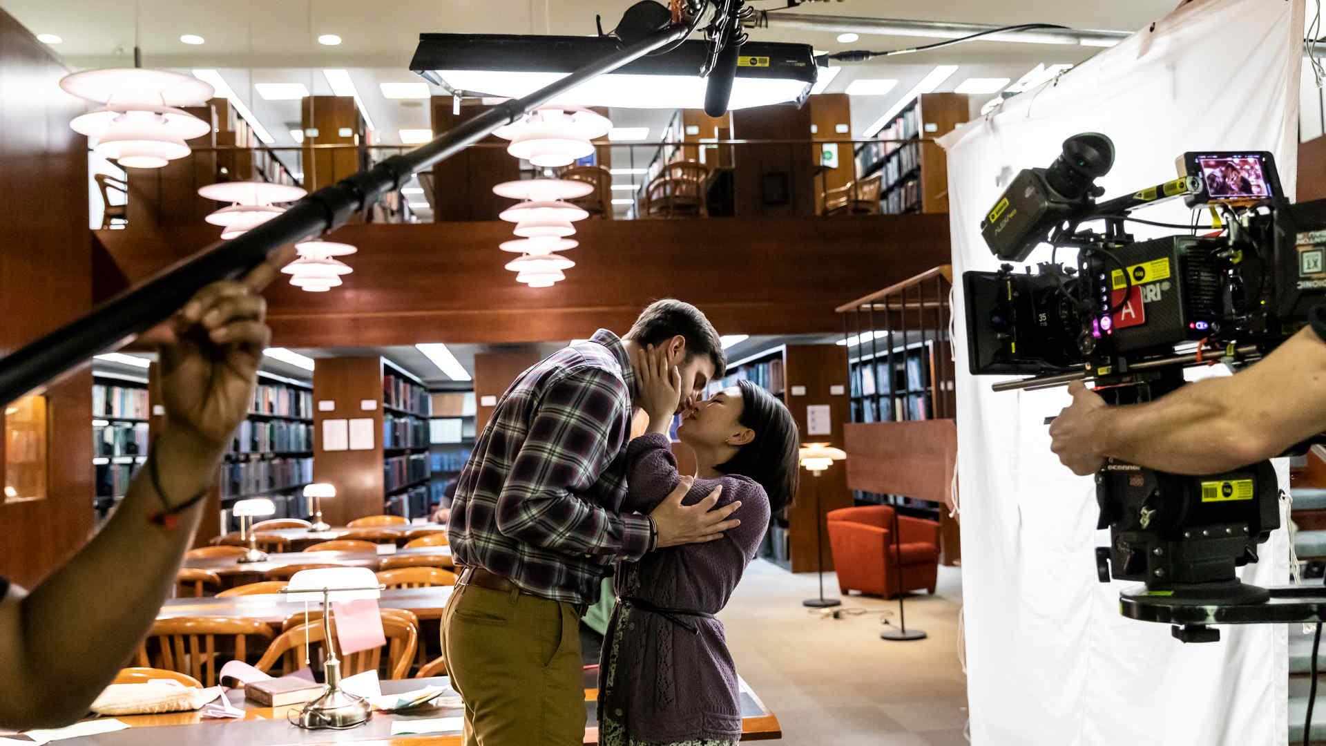 Two actors on film set in a library