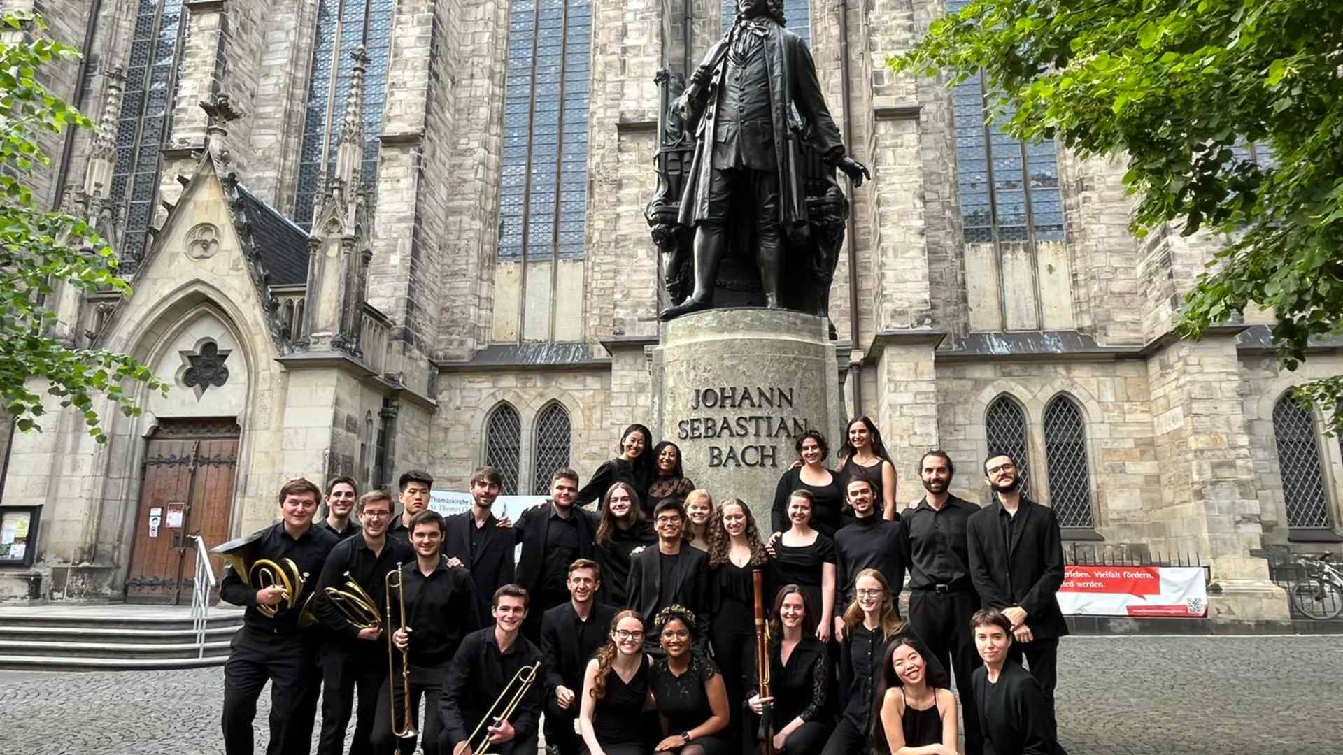 Students pose with a statue of J.S. Bach