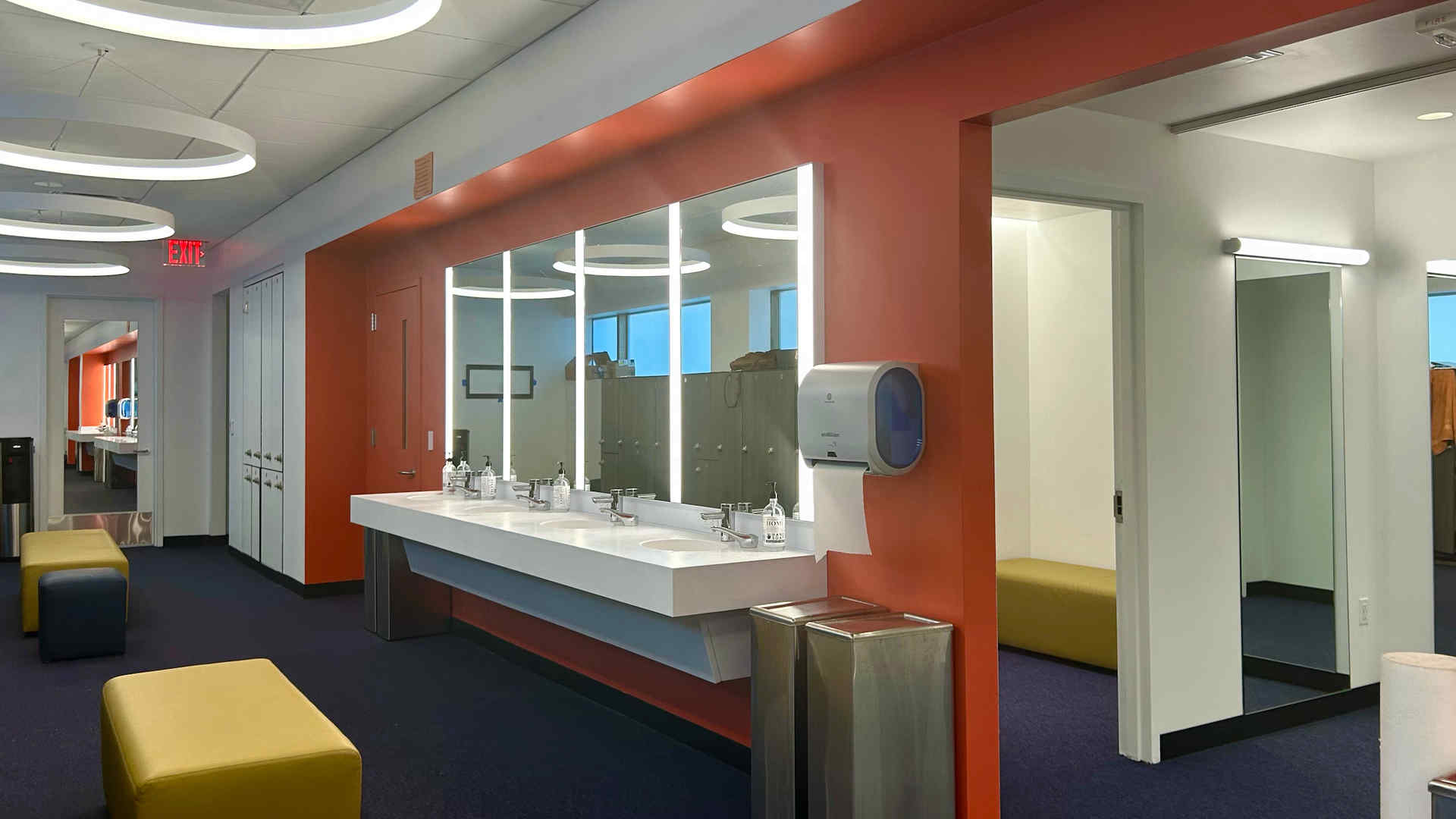 Image of the interior of the newly renovated space showing a dressing room with mirrors, sinks, seating area, and lockers