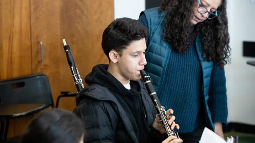 A boy is Playing the clarinet during a MAP class.
