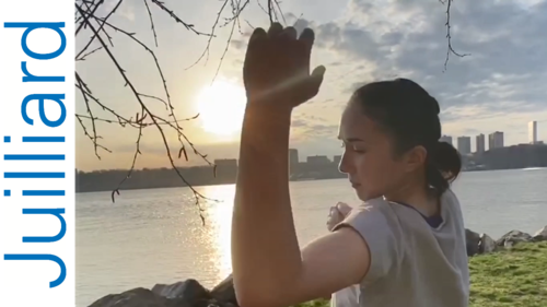 woman dances near river with sunset
