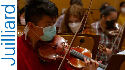 pre-college student playing the violin in the orchestra