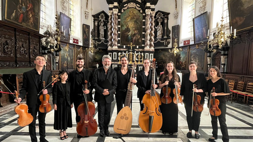 A group photo inside an ornate church of the student and alum players holding their instruments