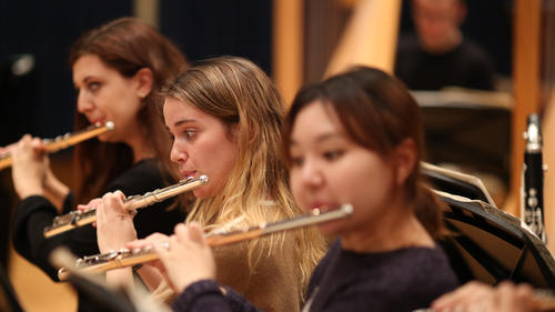 Three flute players rehearsing