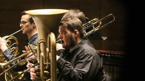Tuba player performing in the brass section of the orchestra